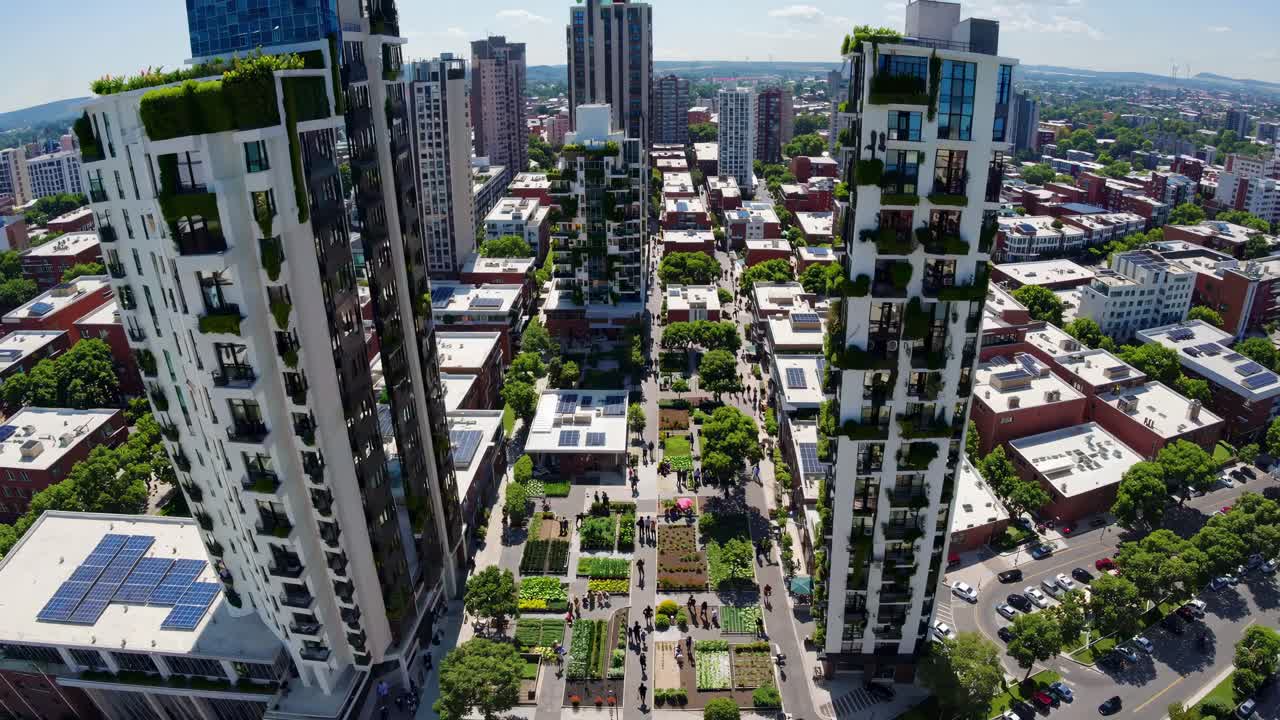 Aerial video shot of a modern urban park flanked by tall, green-clad buildings