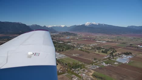 Piper-Pa28-En-Vuelo,-Vista-Del-Piloto-Del-Ala-Y-Un-Soleado-Paisaje-Montañoso