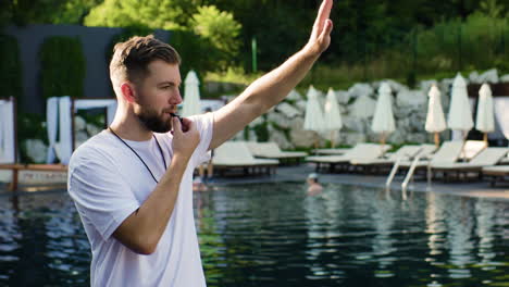 lifeguard using whistle in the swimming pool