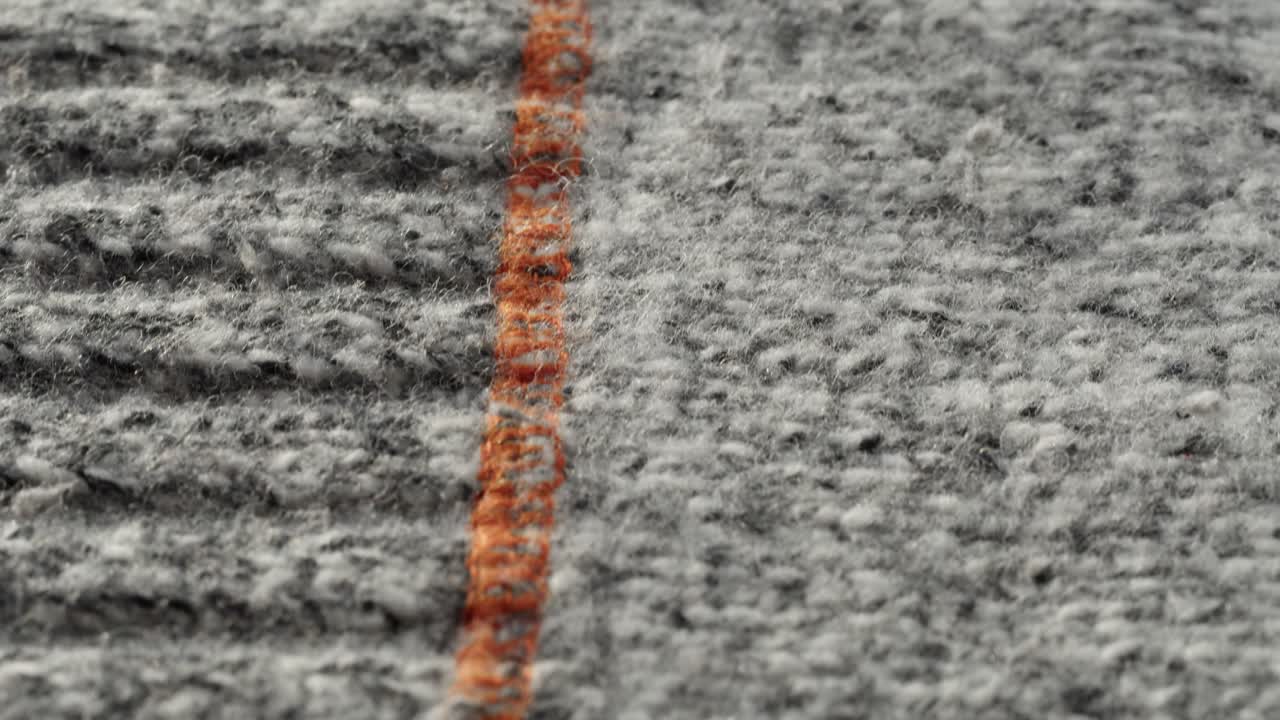 Primo piano della texture di tessuto grigio con striscia arancione