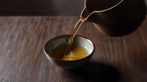 pouring tea into a ceramic cup