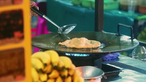 Filmische-4K-Kochaufnahmen-Eines-Thailändischen-Kochs,-Der-Auf-Einem-Straßenmarkt-In-Thailand-Ein-Traditionelles-Thailändisches-Dessert-Namens-Roti-Zubereitet