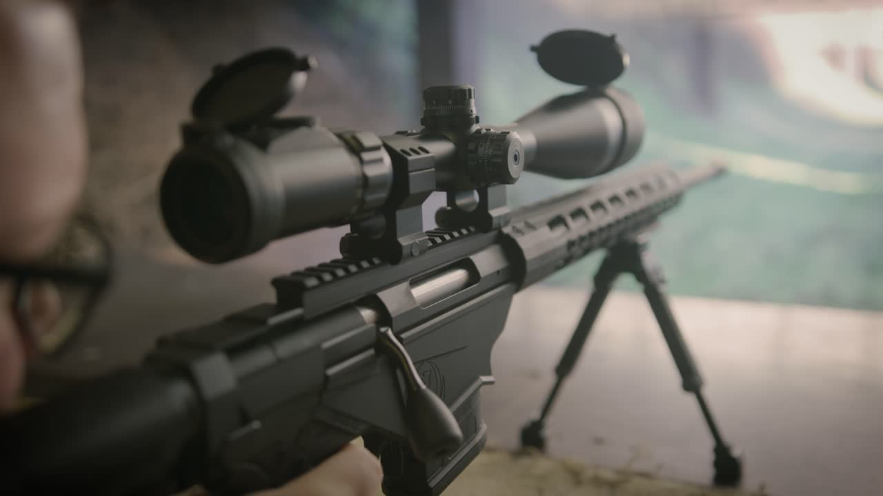стрелок стреляет из снайперской винтовки в тире, крупный план оружия
