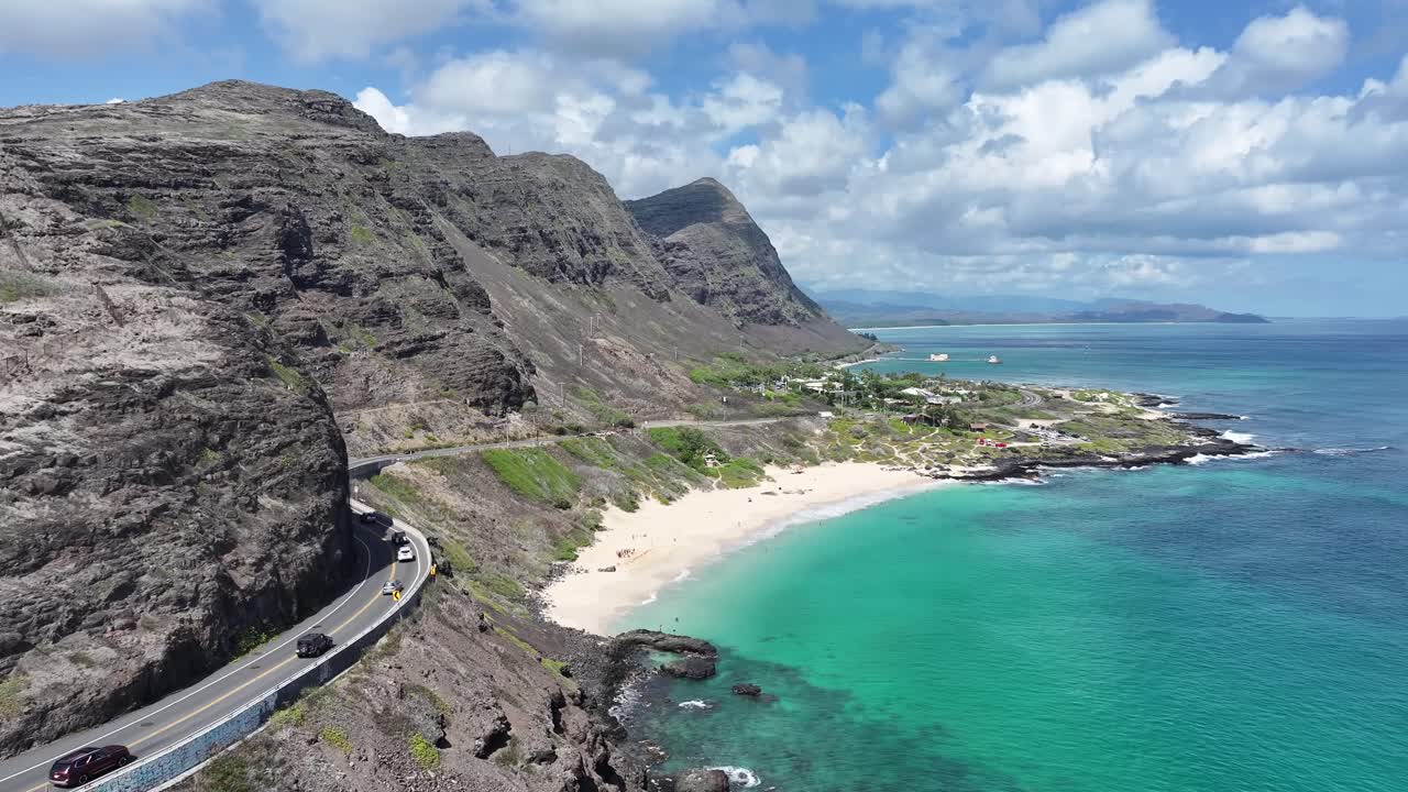 Filmato aereo realizzato con drone sulle lussureggianti montagne verdi e sulla costa tropicale delle Hawaii, che mostra le acque turchesi dell'oceano, le palme, le valli panoramiche e i vivaci paesaggi insulari dall'alto