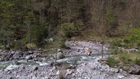 Drone-Fly-next-to-River-with-Crystal-Clear-Water-with-Camp-Fire-Place-on-Small-Island-next-to-it-in-Austria,-Europe