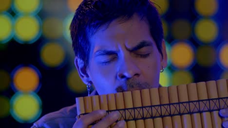 close up shot of musician playing pan flute instrument from andes of peru and bolivia