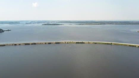 Motorradrennen-Auf-Schmalem-Damm-Im-Věstonice-Stausee,-Drohne