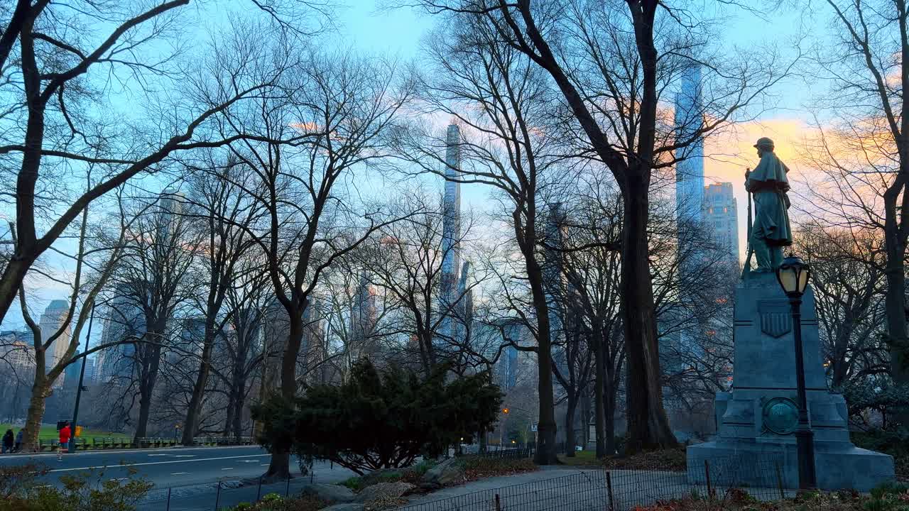 New York, USA, 5 marzo 2026: Monumento della Guerra Civile a Central Park alla luce del tramonto. Statua commemorativa del 7° Reggimento con alberi spogli e grattacieli di Midtown Manhattan sullo sfondo al crepuscolo.