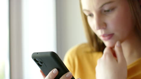 caucasian woman using smartphone at home, in slow motion