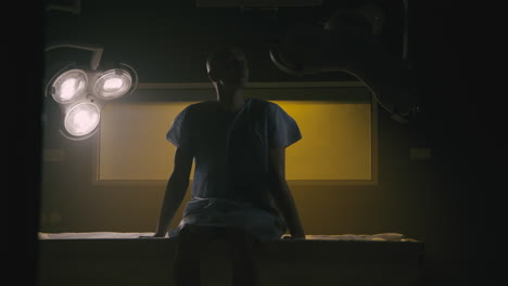 a bald man wakes up in the empty operation room