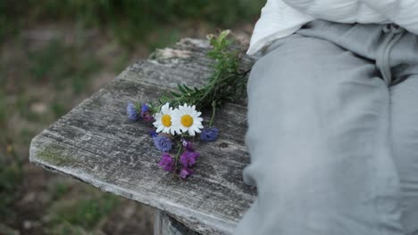 heartbreak chronicles: woman finds solace on a bench, setting aside a symbolic bouquet