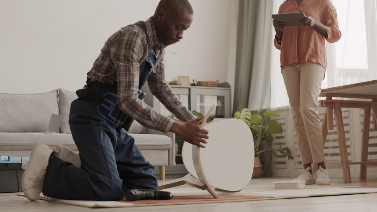 Unrecognizable Woman Watching Handyman Assembling New Chair