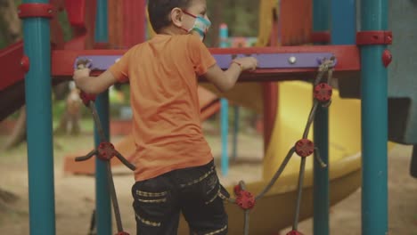 niño enérgico subiendo para subir al tobogán en un parque lleno de diversión, goa, india
