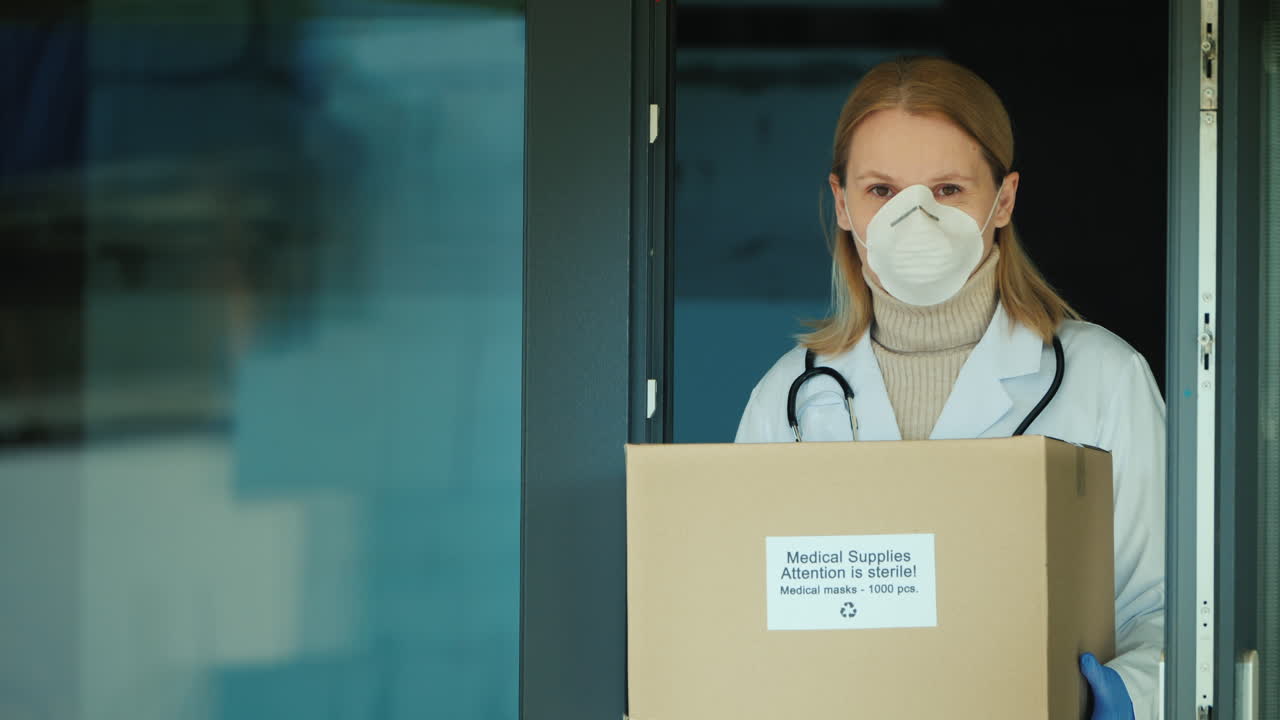 보호용 의료용 마스크 상자를 들고 있는 의사의 초상