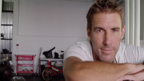 mecánico masculino de pie en el garaje de reparación de motocicletas 4k