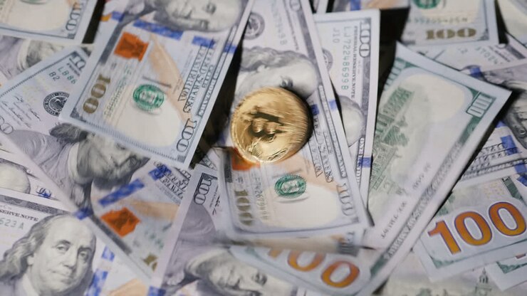 Monete Bitcoin cadono su dollari americani. Concetto di criptovaluta.