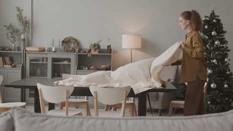 une femme posant une nappe de table à noël