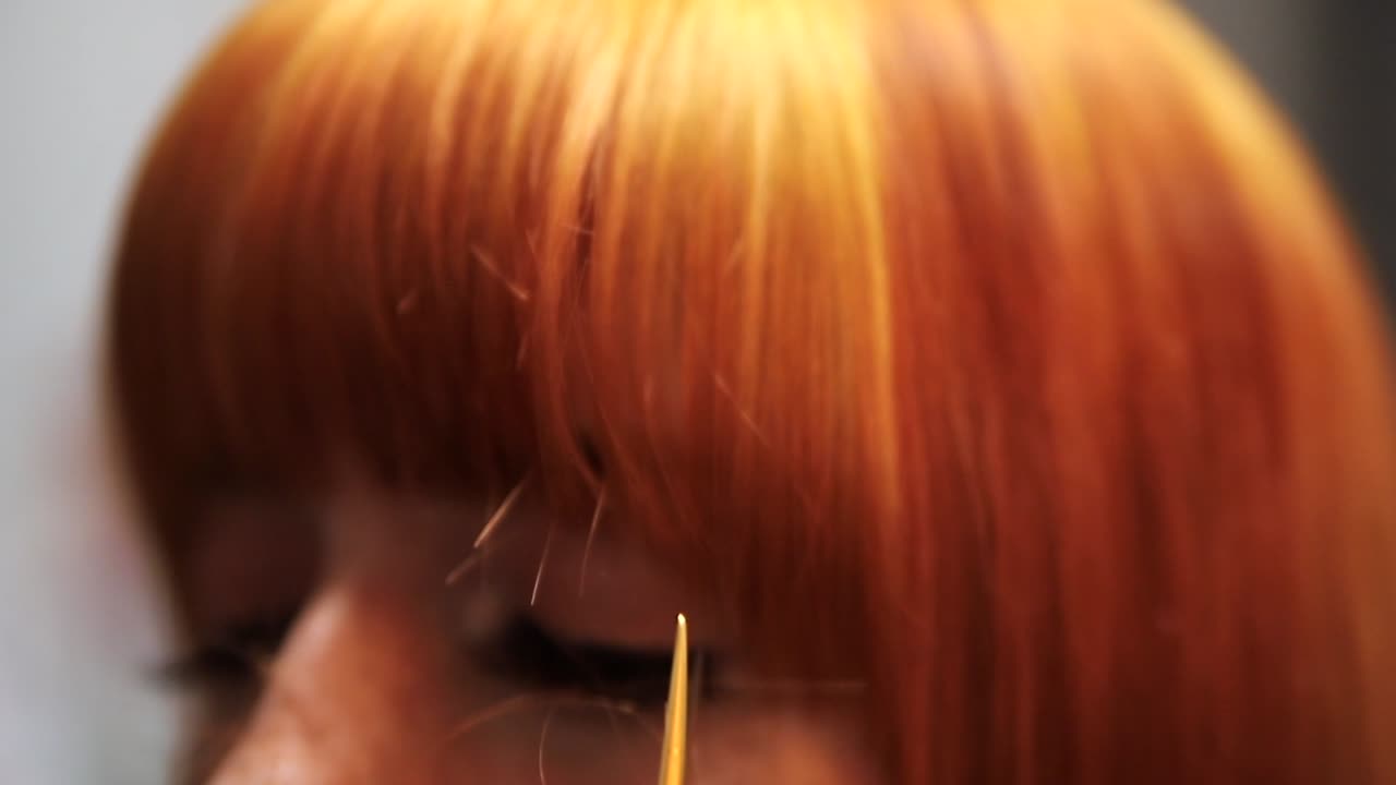 Professional hair stylist thins out red heads bangs.