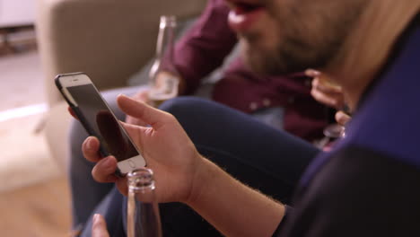 man checking mobile phone at party with friends