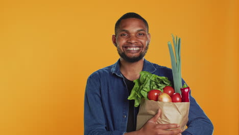 Portrait-of-vegan-person-carrying-a-paper-bag-filled-with-fresh-groceries