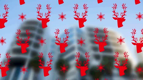 Red-reindeer-and-snowflakes-icons-in-seamless-pattern-against-tall-buildings-in-background