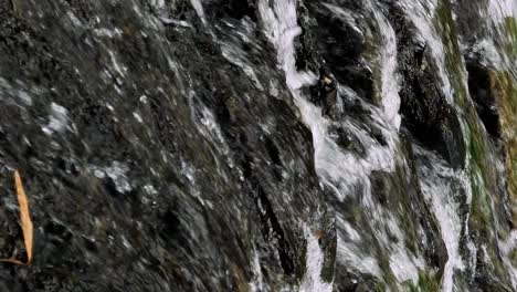 Vertikale-Nahaufnahme-Eines-Fließenden-Wasserfalls-In-Zeitlupe-Mit-Blick-Auf-Die-Steine-In-Bali,-Indonesien