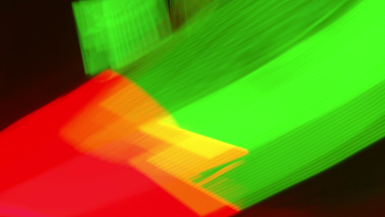 초록색과 빨간색의 흐릿한 움직임은 검은색 배경에서 빠르게 움직입니다.