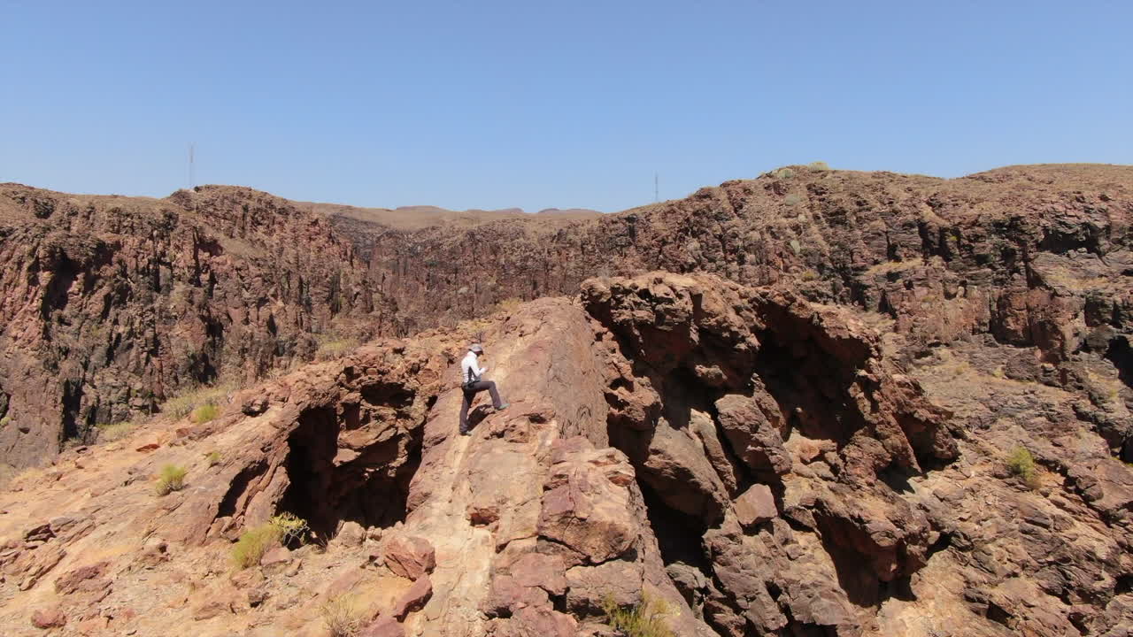 Hiker reaching the summit of Coronadero Arch in Gran Canaria