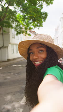 vertical video pov shot of female tourist on vacation in oxford uk exploring city walking along holywell street recording video on mobile phone