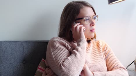 Beautiful-woman-talking-on-mobile-phone-in-living-room