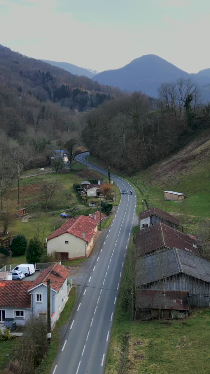 Scenic countryside road with houses and mountains