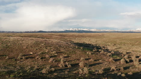 low flying over vast idaho plain toward snow-capped mountains in rural idaho