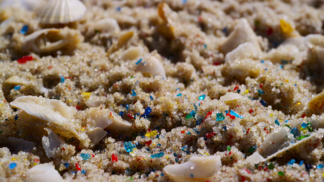 Closeup Sand Shells Microplastic Beads Scattered Across Shoreline, Colorful Plastic Fragments Glint