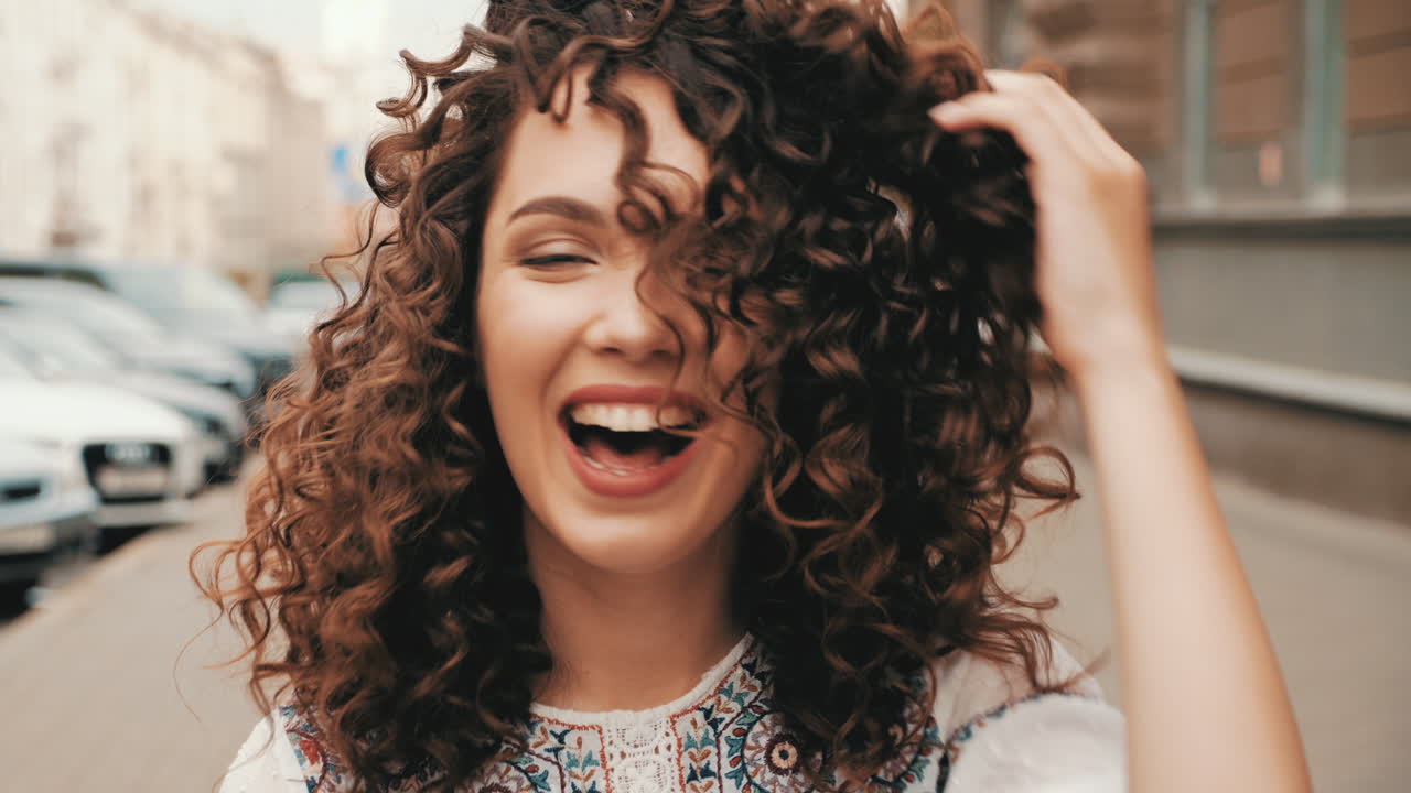 mujer feliz con el cabello rizado