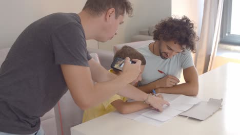 man shooting video of cute son and husband doing home task