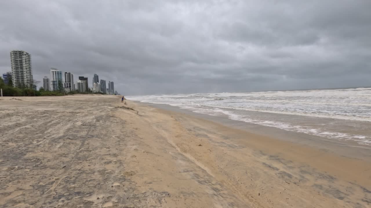 폭풍우가 불어오는 하늘 아래의 황폐한 해변과 격렬한 파도가 다가오는 사이클론의 극적인 분위기를 포착합니다.