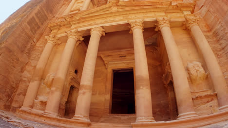 low angle panning shot of the ancient ruins of the treasury in petra