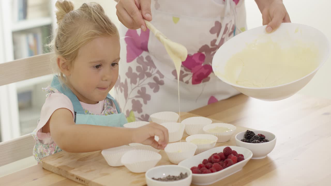 niña pequeña riendo mientras ayuda con el horneado