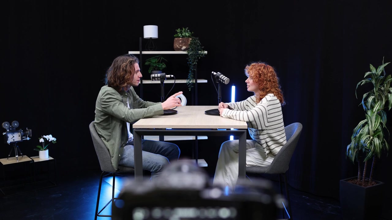Uomo e donna che registrano un'intervista podcast in uno studio moderno