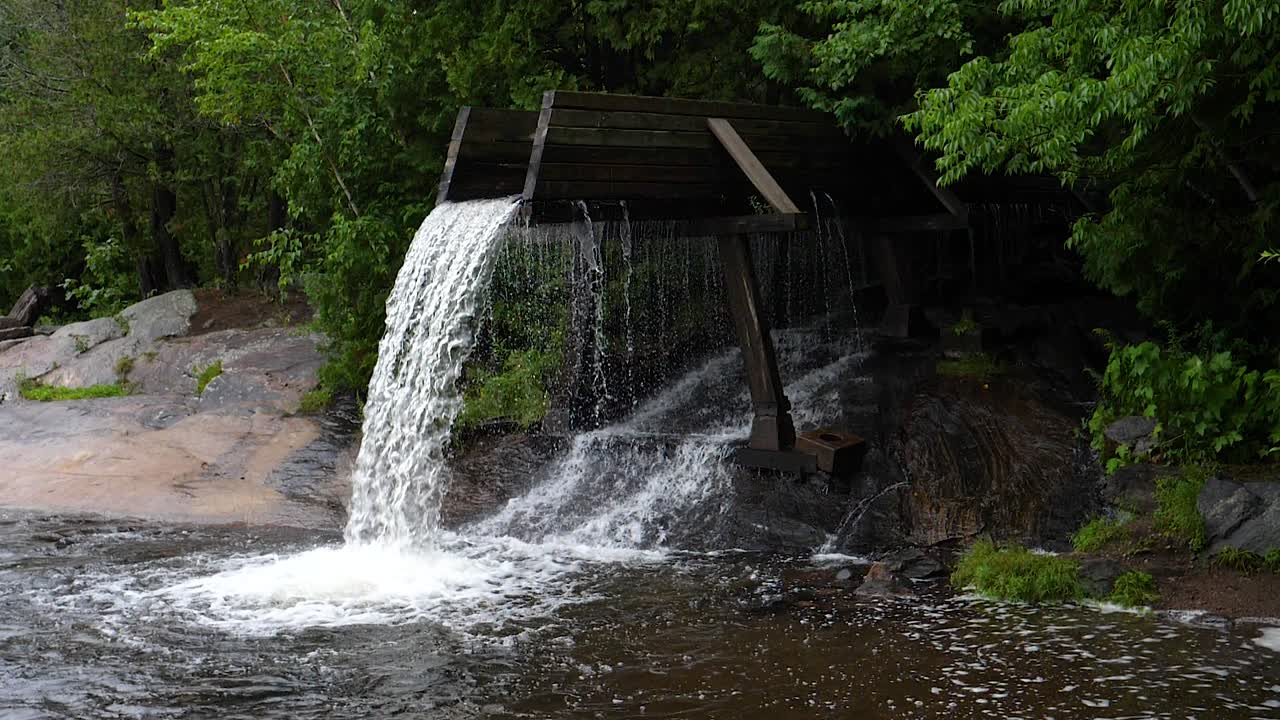 parque de toboganes torcidos, combermere ontario - cámara lenta de 180 fps - cascada de agua de gran angular que cae desde el conducto de troncos antiguo