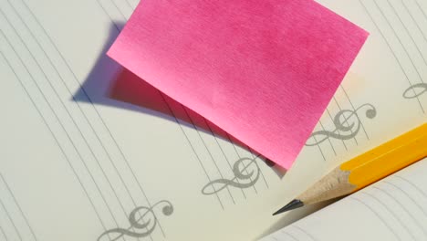 pencil on music note book with post it paper