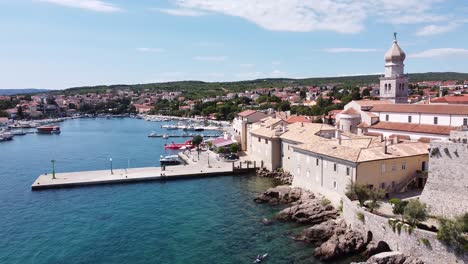 krk village at krk island, croatia - aerial drone view of the bay with church, cathedral, city walls, port, boats and boulevard at the adriatic sea