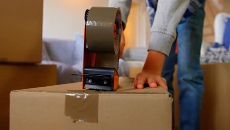 Mid section of boy packing cardboard boxes in a comfortable home 4k
