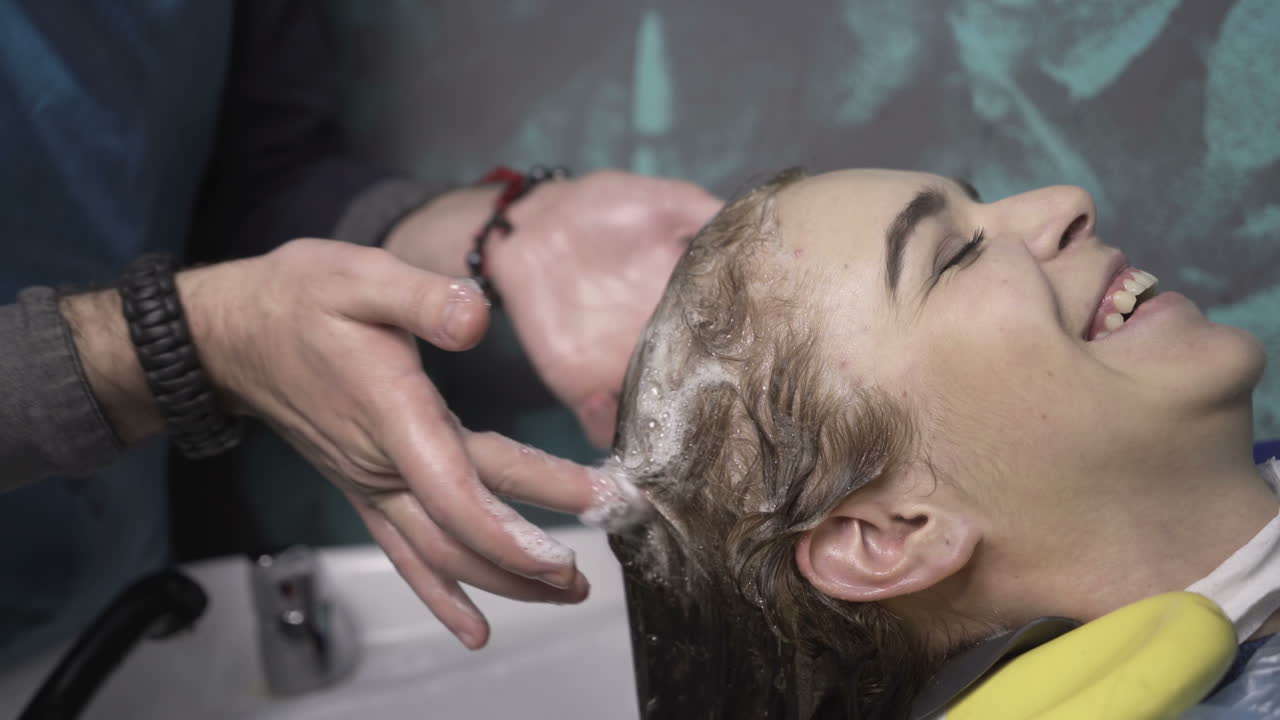 Young woman with hairdresser cutting hair at salon