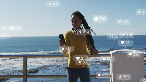 social media interaction icons animation over woman using smartphone by ocean
