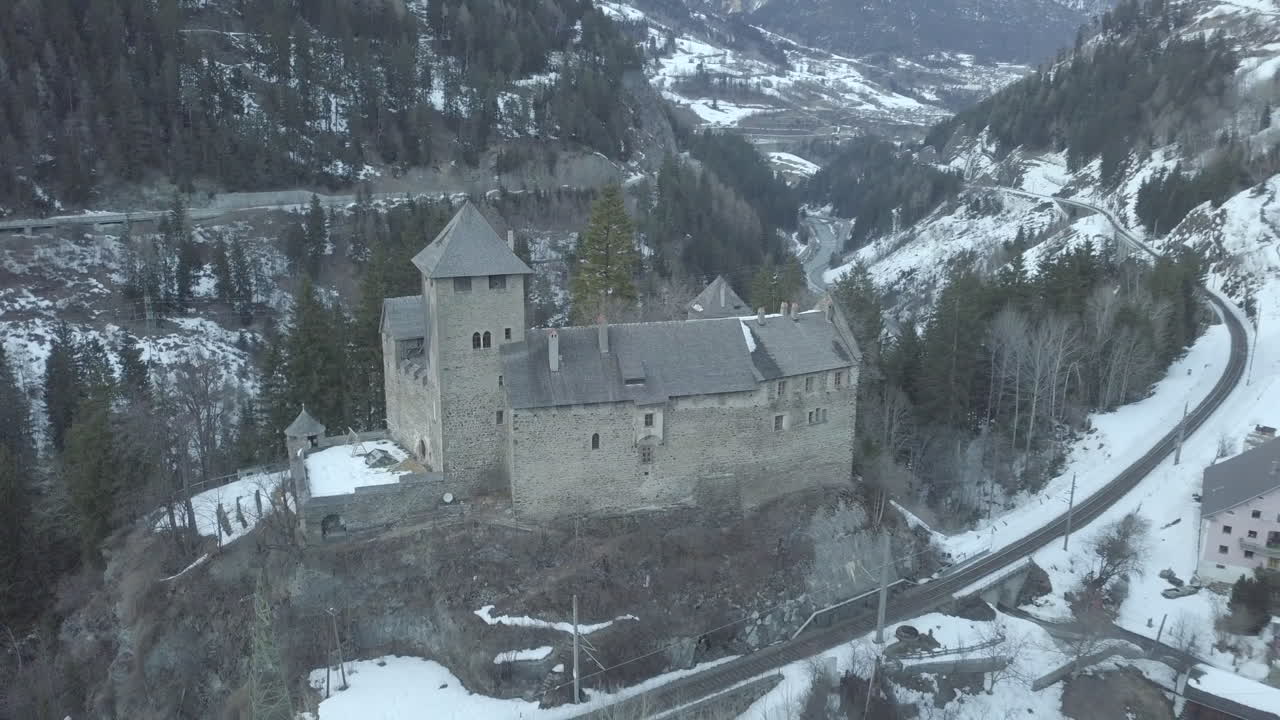 Beautiful castle on a top of a mountain next to train tracks in austria