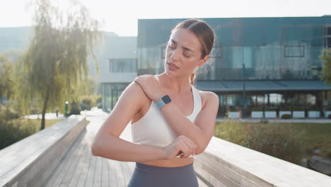 young sportswoman suffers from sharp pain in shoulder during morning jog workout in urban city park