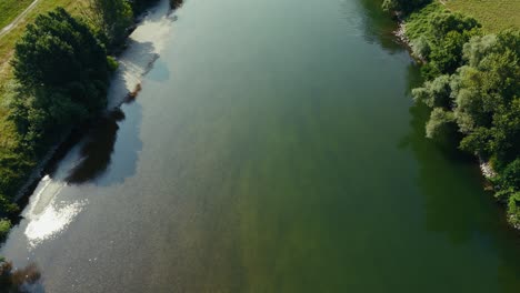 drone captures green tinted shallow water of sava river with tree shadows along quiet banks