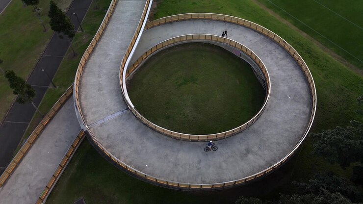 Large spiral bridge aerial view carrying pedestrians and cyclists.