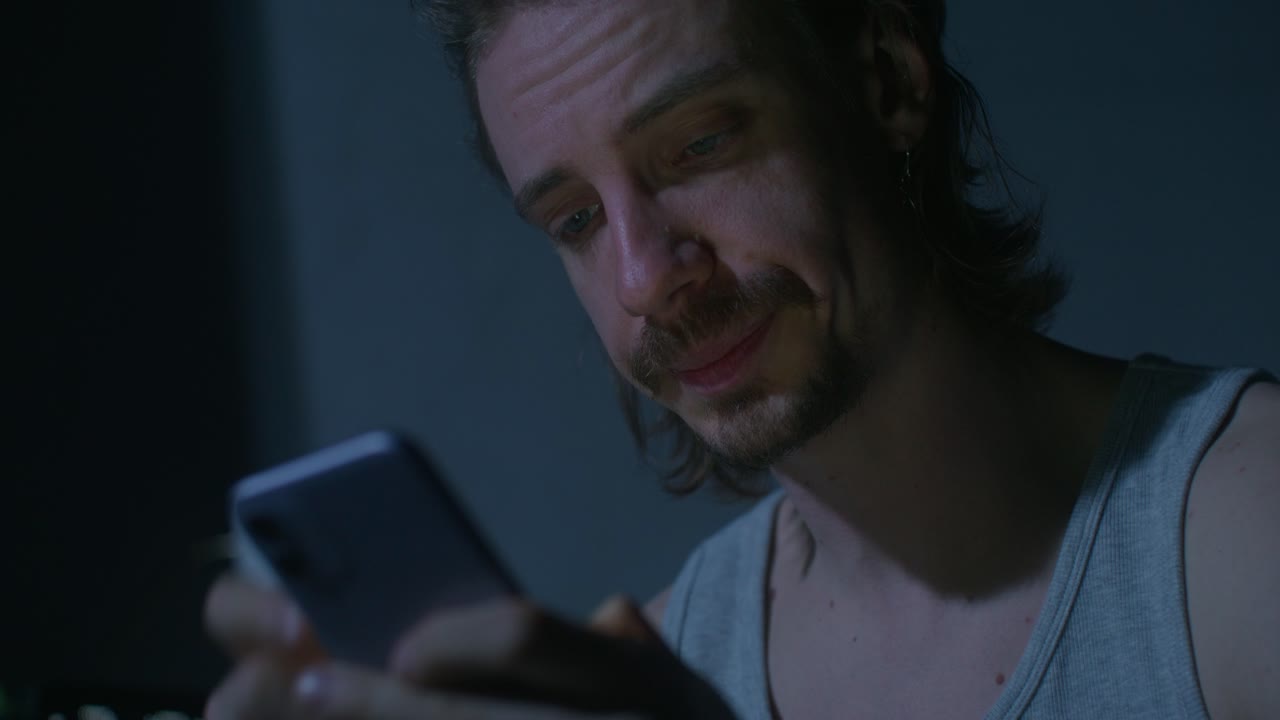 hombre mirando su teléfono inteligente por la noche